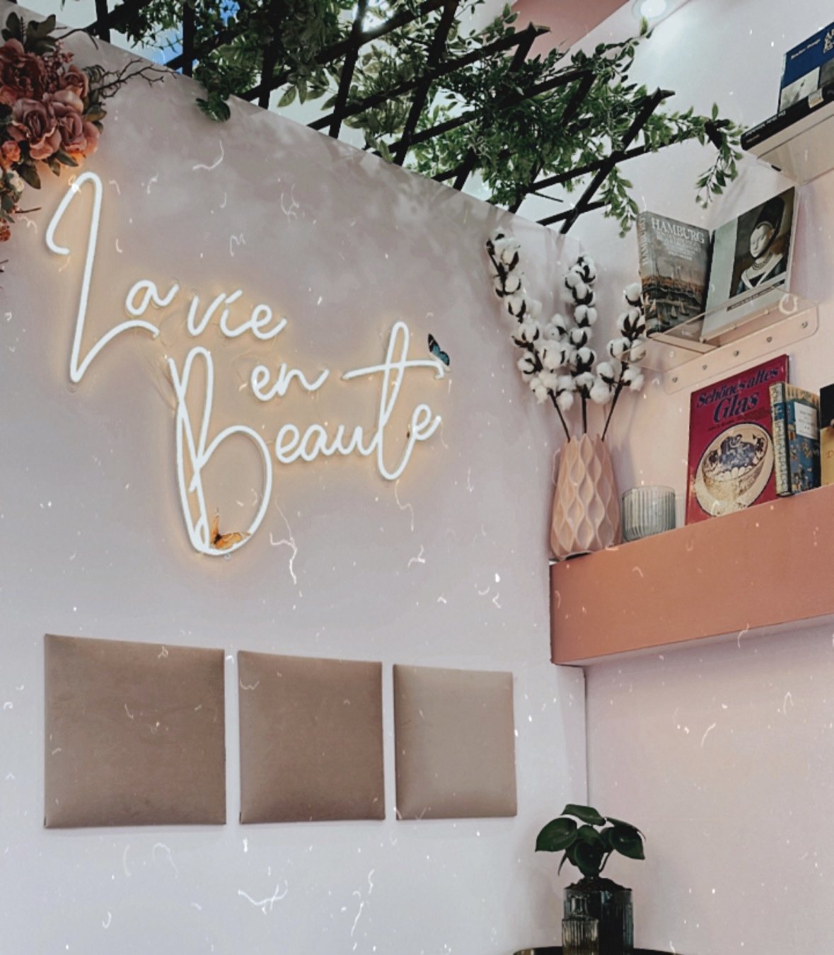 Neon-Schriftzug La vie en Beaute über der Sitzecke im Studio