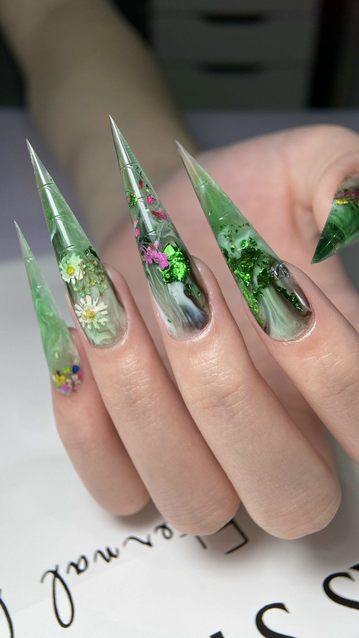 Transparentes Nageldesign mit getrockneten Blüten und Blattgold