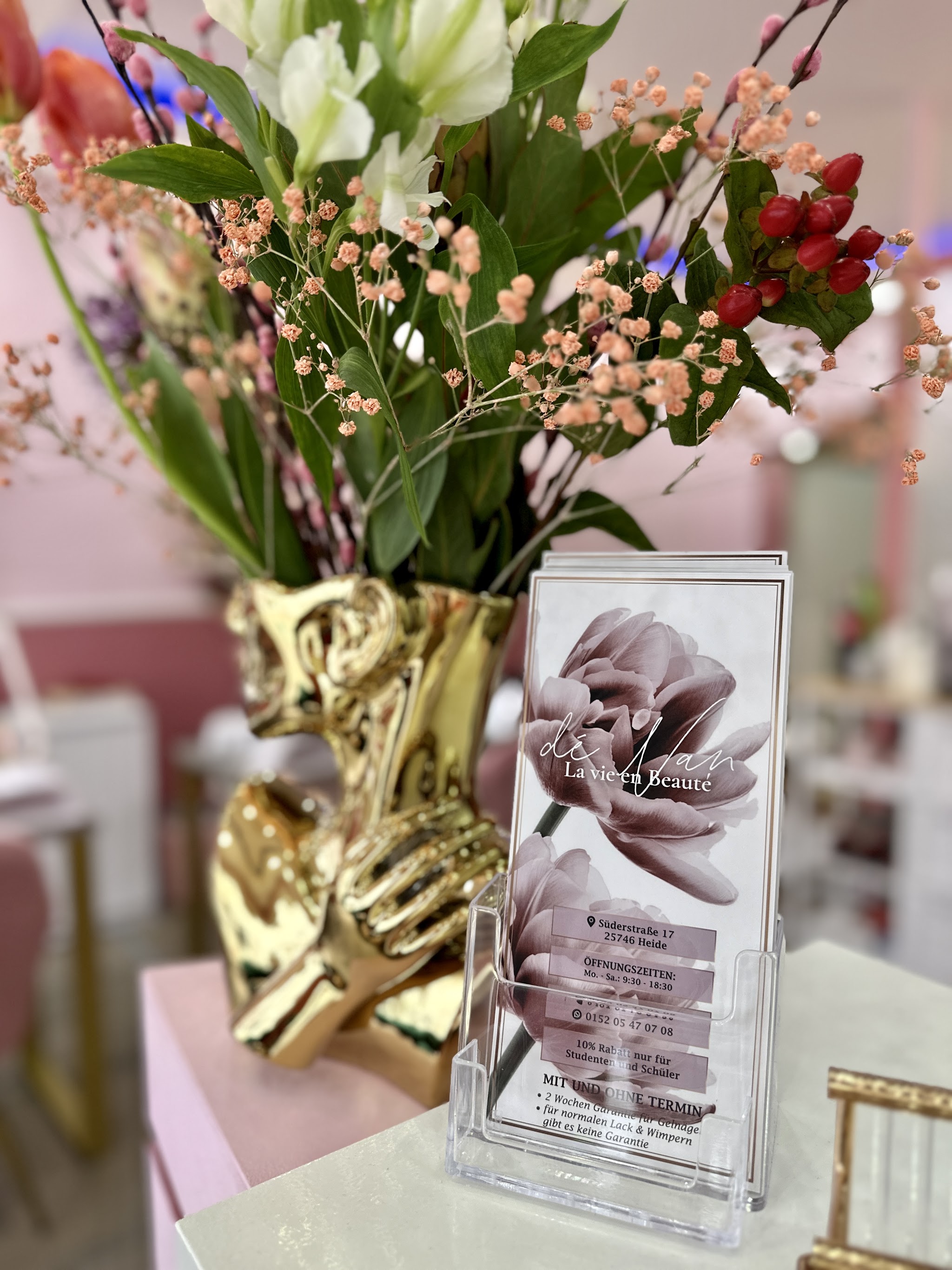Rezeption mit Blumen und Flyer-Ständer im Markendesign