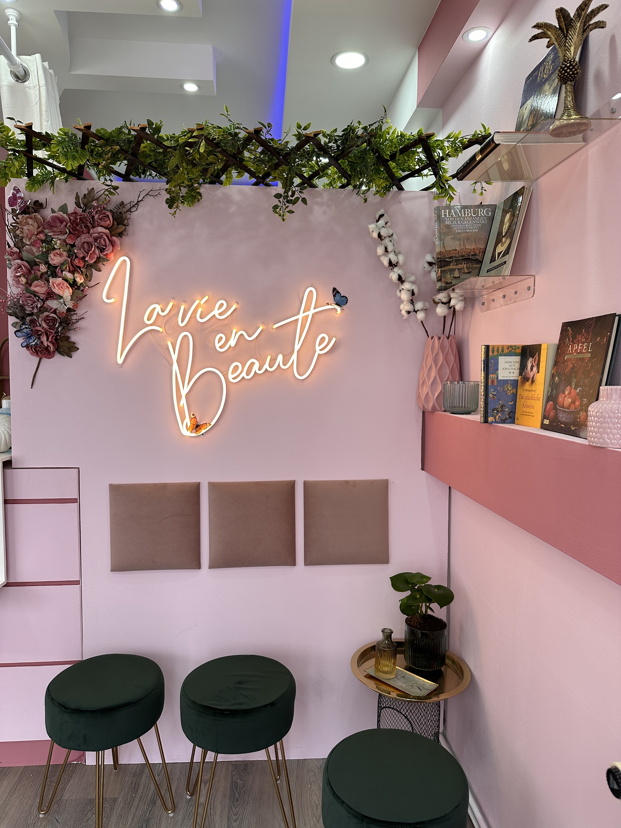 Lounge-Bereich im Studio mit Neon-Schriftzug La vie en Beauté